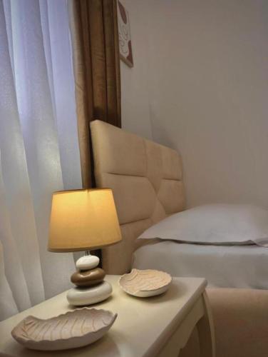 a lamp sitting on a table next to a bed at Vila Dy Bukurite in Draçi