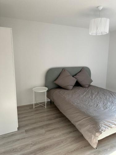 - une chambre avec un lit et une petite table dans l'établissement Appartement neuf en centre ville de Libourne, à Libourne