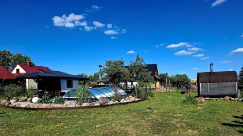 a yard with a house with a boat in it at Domek Walentinki in Rogacze