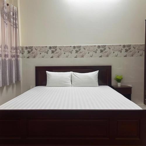 a bedroom with a large bed with white sheets at Hùng Anh Boutique Hotel - Nhà Ga T3 in Ho Chi Minh City