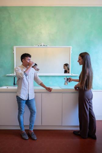 a man and a woman looking at a dog in a mirror at Tenuta Santa Trice in Riotorto