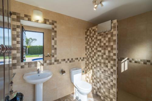 un bagno con un water e un lavandino di Casa rural Buhaira a La Puebla de Cazalla