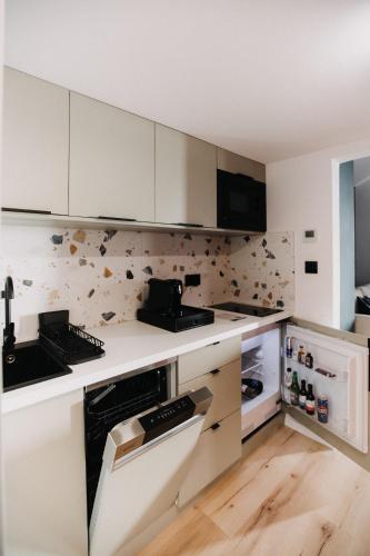 a kitchen with white cabinets and a stove top oven at Szépasszony Guest House in Vlăhiţa
