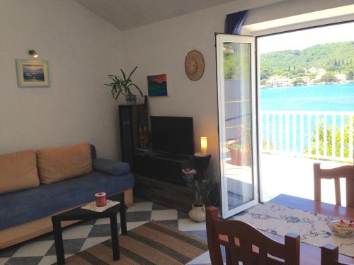 ein Wohnzimmer mit einem Sofa und einer Glasschiebetür in der Unterkunft Apartments Capitano Blue in Zaton