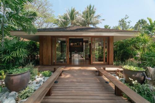 a home with a wooden walkway leading to the front door at Barcelo Coconut Island, Phuket in Phuket Town