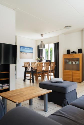 a living room with a couch and a table at -Duinhuisje - voor families & honden nabij strand in Noordwijk