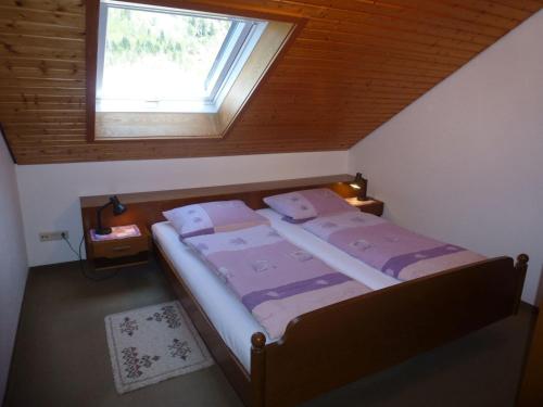 una piccola camera da letto con un letto e una finestra di Haus Huber a Wolfach