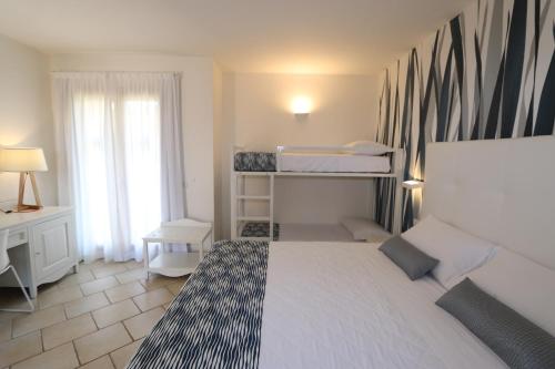 a small bedroom with a bed and a desk at Janna e Luna Resort in Agrustos