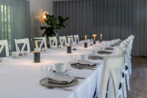 a row of tables with white linen and candles at Fakkelgaarden Hotel & Restaurant in Kruså