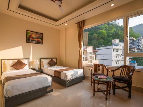 a hotel room with two beds and a window at Moustache Select Rishikesh in Rishīkesh