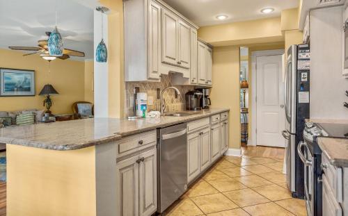 a kitchen with white cabinets and granite counter tops at 115 Capt John Fripp Villa in Fripp Island