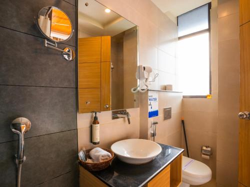 a bathroom with a sink and a toilet and a mirror at Moustache Select Rishikesh in Rishīkesh