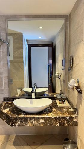 a bathroom with two sinks and a large mirror at Grand Ocean El Sokhna in Ain Sokhna