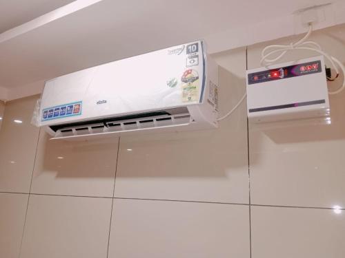 a microwave oven sitting on top of a white wall at GM Residency Beach Inn in Velankanni