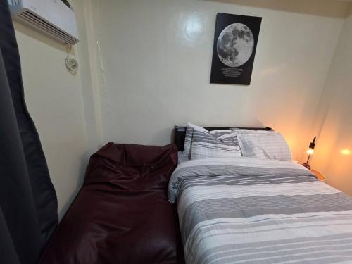 a bedroom with a bed and a picture of the moon at Pioneerwoodlands Mandaluyong Studio Unit in Manila