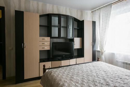 リュベルツィにあるDearHome Mitrofanovaのベッドルーム1室(ベッド1台、壁にテレビ付)