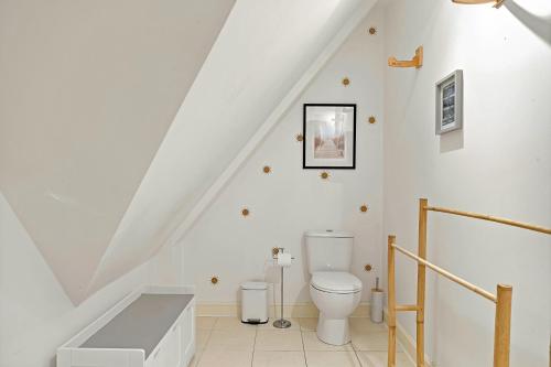 a white bathroom with a toilet in the attic at Pentire Point - Coastal Penthouse, Beaches, River & Restaurants All Within Short Walk in Newquay