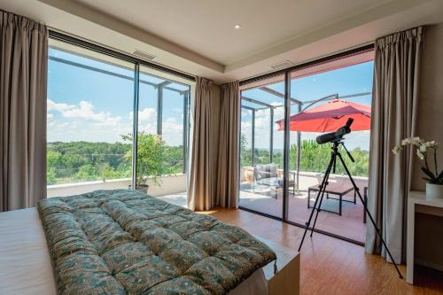 une chambre avec un lit, un parapluie et un trépied dans l'établissement Domaine de la Peyrine - Suite Pinson, à Carignan