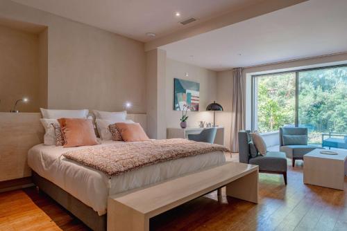 une chambre avec un grand lit et une grande fenêtre dans l'établissement Domaine de la Peyrine - Suite Mésange, à Carignan