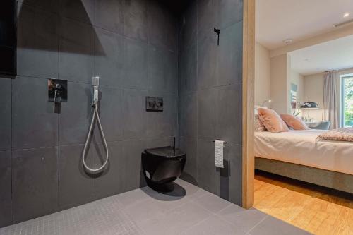 Cette chambre comprend un lit et une salle de bains pourvue d'une douche. dans l'établissement Domaine de la Peyrine - Suite Mésange, à Carignan