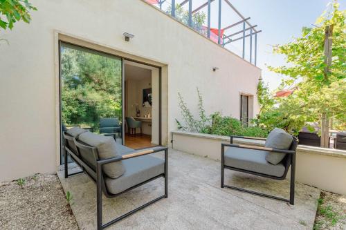 un groupe de chaises assises sur une terrasse dans l'établissement Domaine de la Peyrine - Suite Mésange, à Carignan