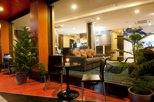 a living room with a couch and a table and plants at 41 Suite Bangkok in Bangkok