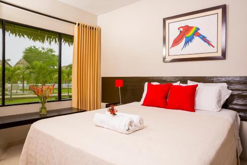 a bedroom with a bed with red pillows and a window at Irapay Amazon Lodge in Padre Cocha