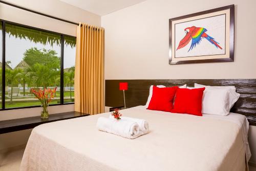 Un dormitorio con una cama con almohadas rojas y una ventana en Irapay Amazon Lodge - Asociado Casa Andina, en Padre Cocha