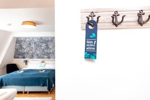 a bedroom with a blue bed and a sign on a wall at Hotel Bethanien in Langeoog
