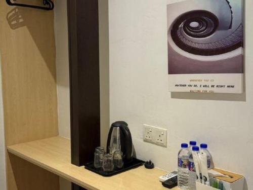 a counter with bottles of water and a telephone at Hotel Zamburger Bentong in Bentong