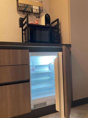 an open refrigerator with a microwave on top of it at San Valentino House in Bussolengo