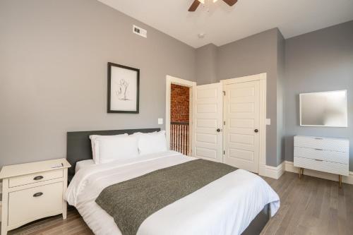 Un dormitorio con una cama blanca y una ventana. en Parkside Comfort | JZ Vacation Rentals, en Tower Grove