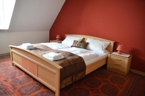 a bedroom with a large bed with red walls at Weingasthof Zum weißen Roß in Osthofen