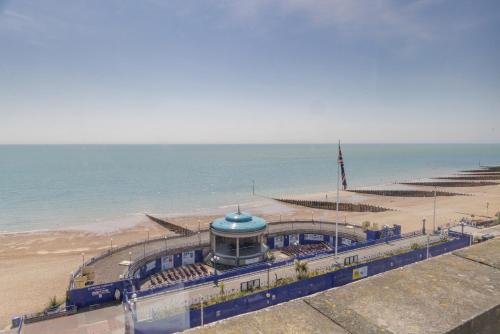a building on the beach next to the ocean at The Cumberland Hotel in Eastbourne