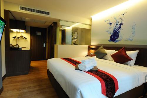 a bedroom with a large white bed with red pillows at 41 Suite Bangkok in Bangkok