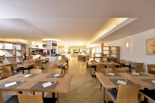 a restaurant with wooden tables and chairs and a cafeteria at Janna e Luna Resort in Agrustos