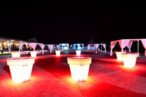 a row of tables with red lights in front of white tents at Janna e Luna Resort in Agrustos