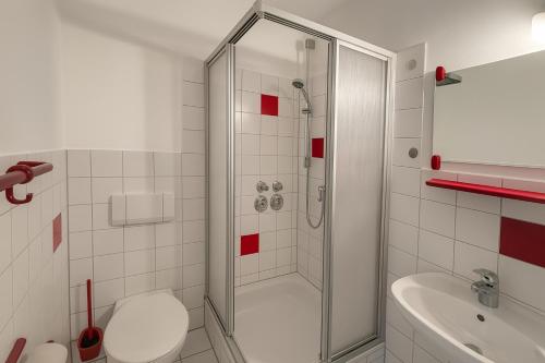 a bathroom with a shower and a toilet and a sink at BoardingHouse - Studios & Apartments in Kassel