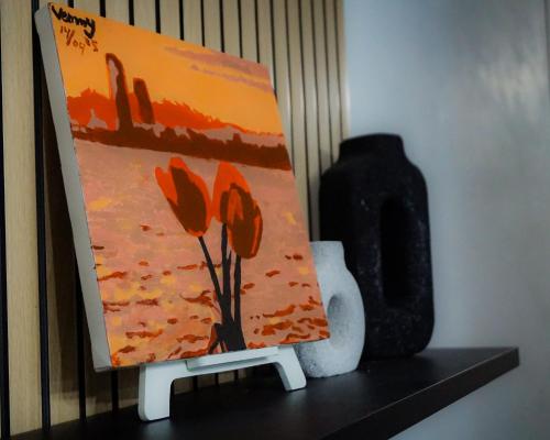 a painting sitting on a shelf next to a vase at Villa Kami Cijeruk in Cihideung