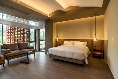 a large bedroom with a bed and a couch at Guanlu Art Hotel in Huadu