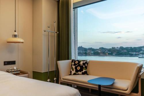 a room with a couch and a window with a view at 茑岛海景潮宿NiaoDao Seaview Hotel in Xiamen