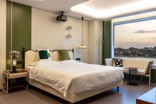 a bedroom with a large bed and a large window at 茑岛海景潮宿NiaoDao Seaview Hotel in Xiamen