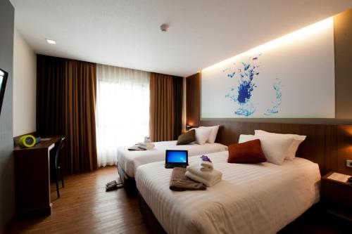 a hotel room with two beds with a laptop on them at 41 Suite Bangkok in Bangkok