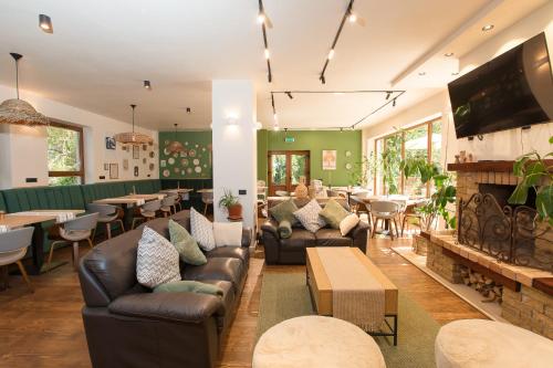a restaurant with couches and tables and a fireplace at Pensiunea Bucuria Cheia & Ferma Animale in Cheia