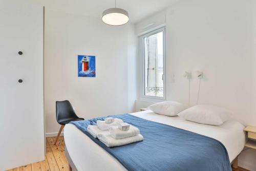 une chambre avec un lit avec deux serviettes dessus dans l'établissement Villa au pied de la plage, à Les Sables-dʼOlonne