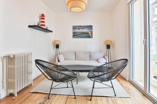 a living room with a couch and a table and chairs at Villa au pied de la plage in Les Sables-dʼOlonne