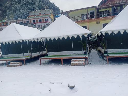 a group of tents with snow on them at Chopta Rock Hill Camp in Chopta