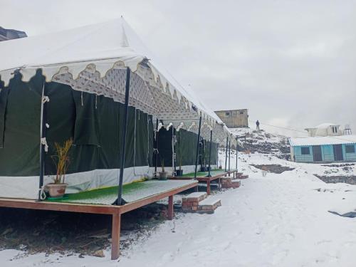 a row of tents sitting in the snow at Chopta Rock Hill Camp in Chopta