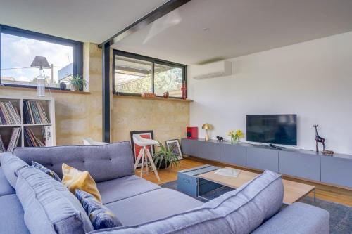 un salon avec un canapé bleu et une télévision dans l'établissement Character villa with pool, à Izon