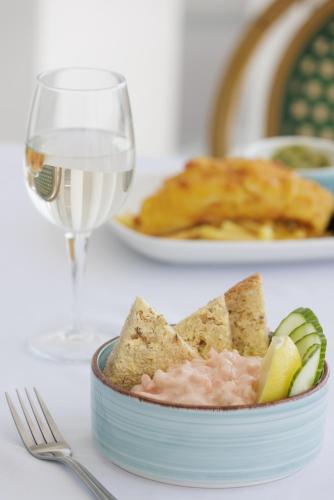 a bowl of food with a glass of wine and a plate of food at The Cumberland Hotel in Eastbourne